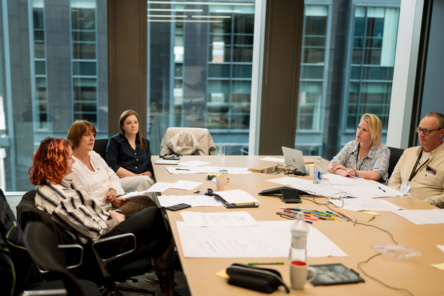 Break the Silence trustees discussing strategy around a boardroom table.